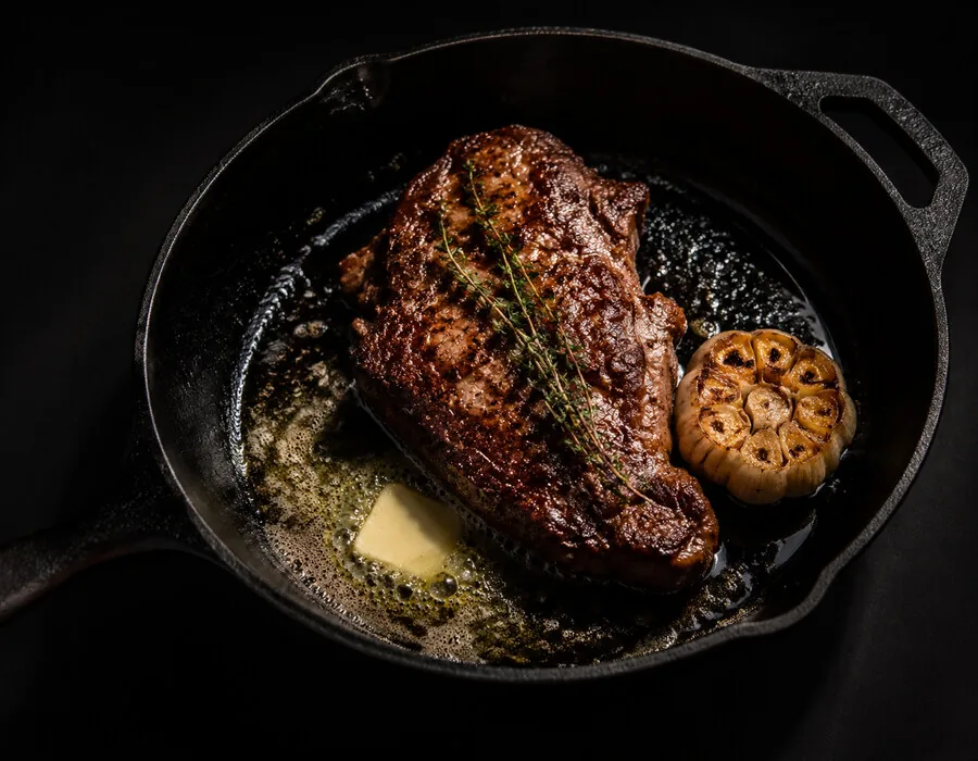 Steak in der Gusseisenpfanne mit Butter und Thymian